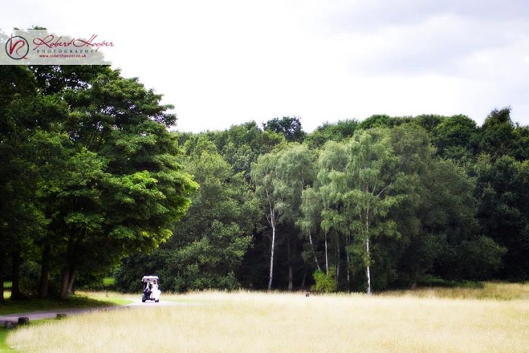 Bride and groom in golf buggy at Painshill Park