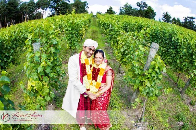 Newlywed bride and groom pose in the vineyards at Painshill Park