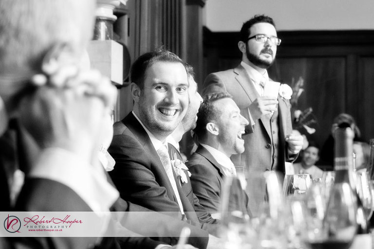 Groom laughing during best man speech 