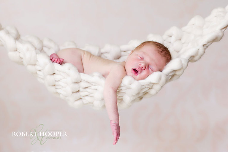 Sleeping newborn in hammock sling