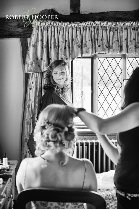 Bridemaid smiling at bride during bridal preps at Cain Manor in Surrey