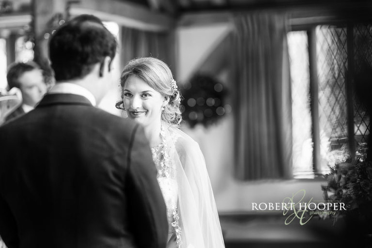 Bride smiling at her groom during vows at Cain Manor wedding venue in Surrey