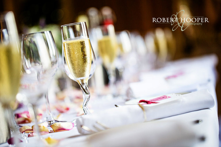 Unusual champagne glass filled with champagne for toasts during speeches at wedding breakfast at Cain Manor in Surrey