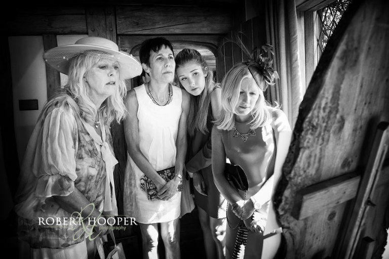 Wedding guests looking at table plan for wedding breakfast at summer wedding at Cain Manor Surrey