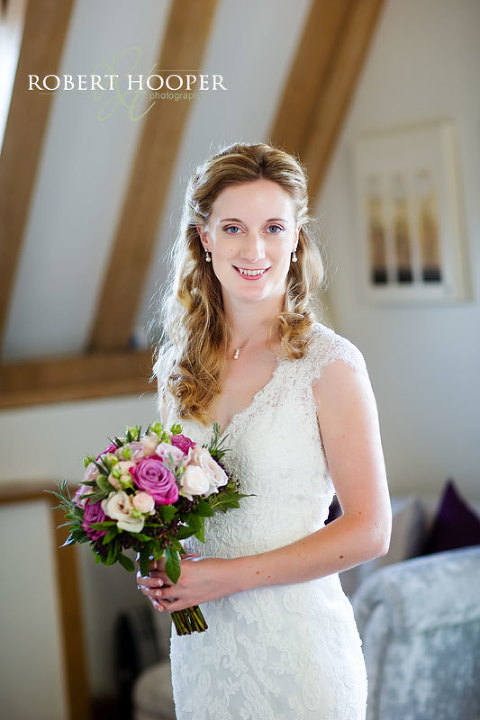 Kent bride having bridal portrait with bouquet of pink roses at Cooling Castle Barn in Rochester, Kent