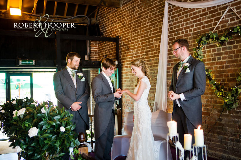 Kent wedding couple exchanging rings on their wedding day at Cooling Castle Barn in Rochester, Kent