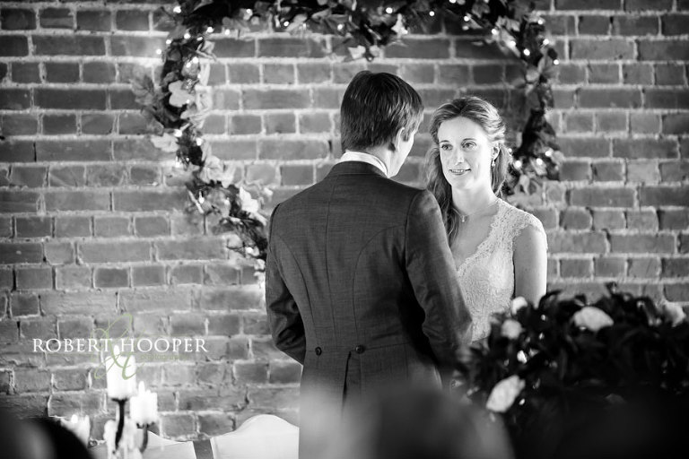 Kent bride gazing at her groom during vows at Cooling Castle Barn wedding in Kent