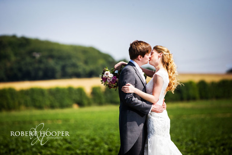 Bride and groom kissing amongst the wilds of the North Kent Marshes after their wedding at Cooling Castle Barn