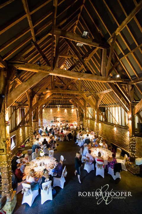 Guests seated during wedding breakfast in Tithe Barn at Cooling Castle in Rochester, Kent