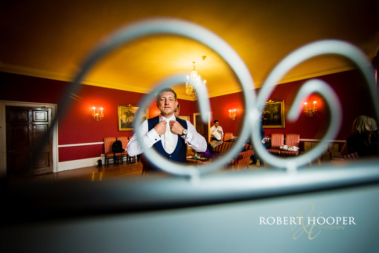 Creative picture of groom during groom preparations for his wedding at Addington Palace in Surrey