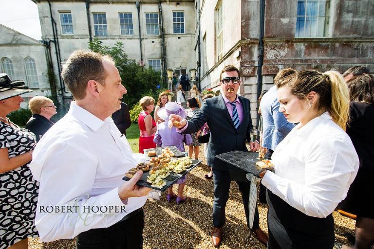 Surrey wedding guests eating canapes at drinks reception at Addington Palace in Croydon, Surrey