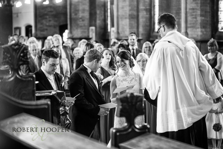 Bride smiling during wedding ceremony at St Andrew The Apostle Parish Church in Catford, London