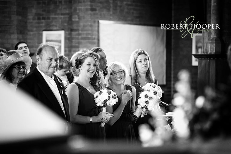 Bridesmaids and family during wedding ceremony in St Andrew the Apostle Church in Catford London