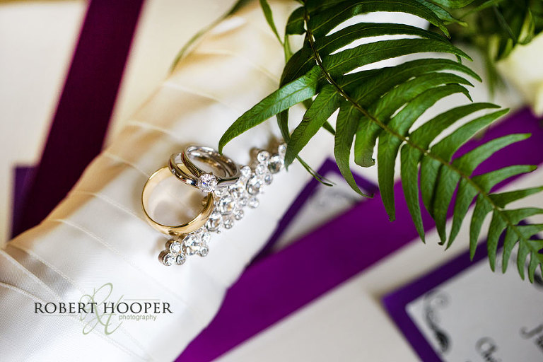 Photograph of wedding and engagement rings on top of bride's bouquet on summer wedding day at Addington Palace in Surrey