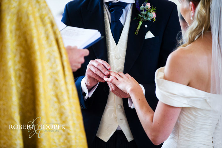 Exchange of rings during marriage service on wedding day at All Saints Church, Orpington, Kent