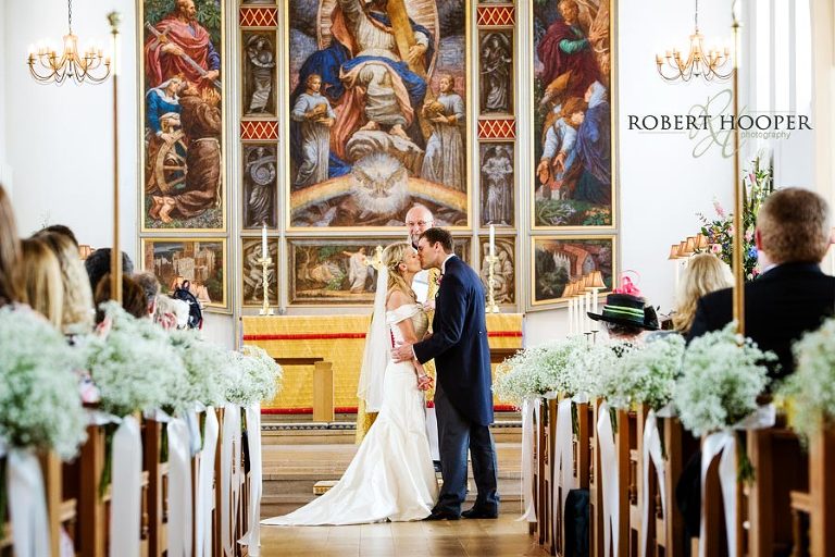 Kent bride and groom kiss during wedding service at ceremony at All Saints Church, Orpington in Kent