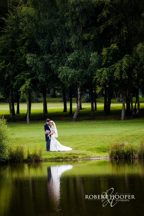Bride and bride groom reflection in the lake on wedding day at Westerham Golf Club in Kent
