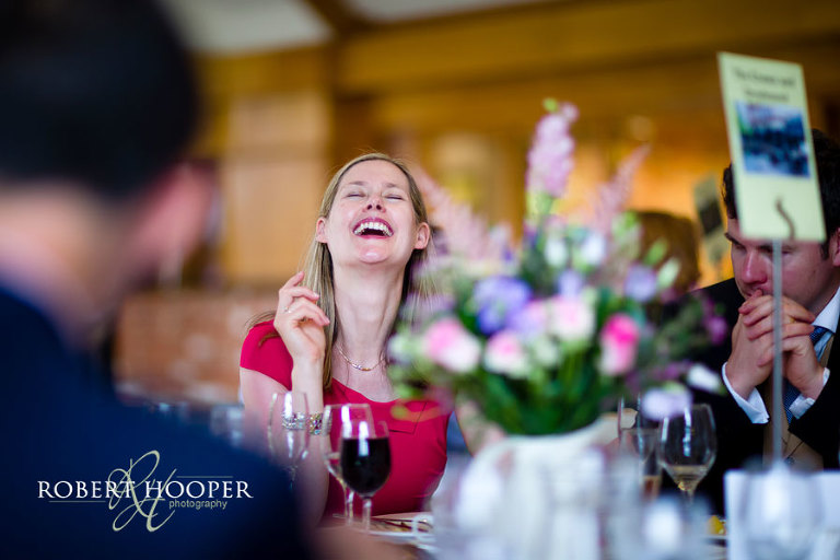 Fun, natural wedding photo of guest laughing during speeches at Westerham Golf Club, Kent