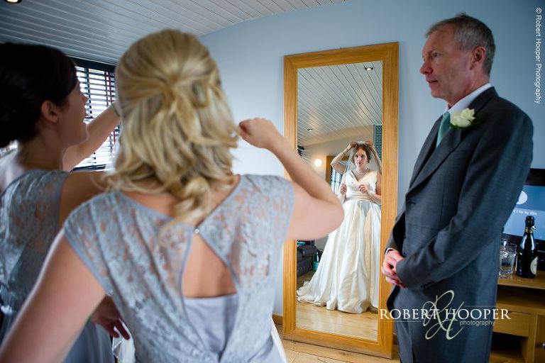 Bridesmaids helping bride with veil on her wedding day at Bix Manor, Henley-on-Thames, Oxfordshire