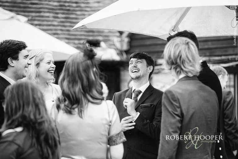 Wedding guests laughing after ceremony at Bix Manor, Henley-on-Thames, Oxfordshire