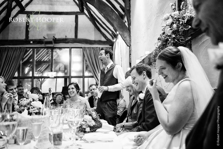 Best man's delivering funny speech at wedding breakfast held in the Great Tithe Barn, Bix Manor, Henley-on-Thames in Oxfordshire
