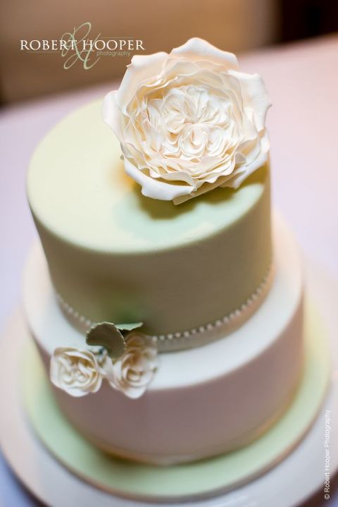 Beautiful cream wedding cake with iced flowers for wedding day held at Bix Manor Oxfordshire