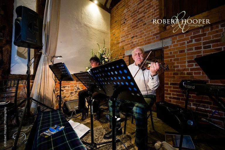Ceilidh band warm up for wedding celebration dancing in Great Tithe Barn, Bix Manor in Oxfordshire