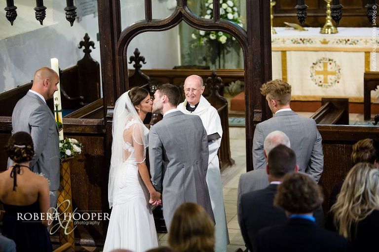 Bride and bride groom kiss after vows on their wedding day in Send, Surrey