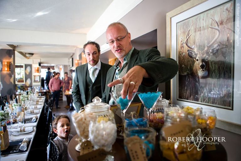 Wedding guests at sweet table at wedding reception at The Stag on the River in Eashing, Surrey