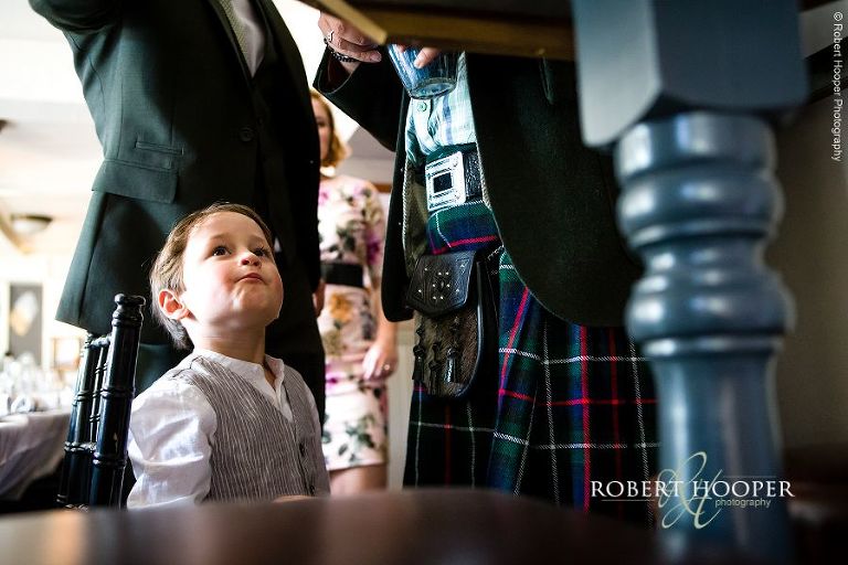 Page boy waiting for sweets from sweet table at wedding reception at The Stag on the River in Eashing, Surrey