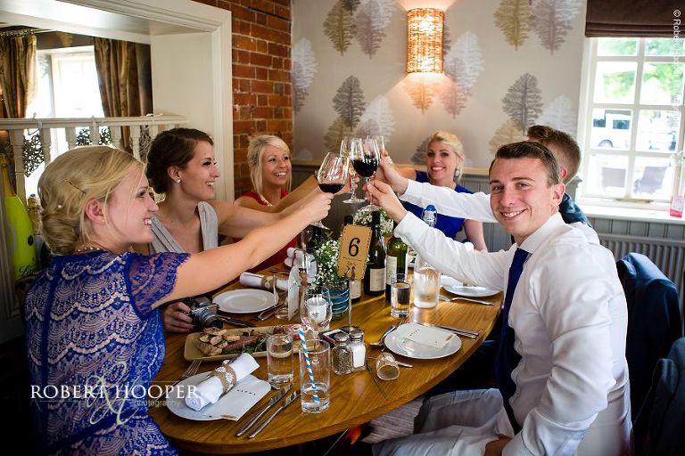 Cheers moment at wedding reception at Stag on the River in Eashing, Surreuy