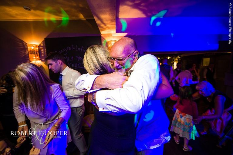 Guests hugging at evening wedding reception at The Stag on the River, Eashing in Surrey