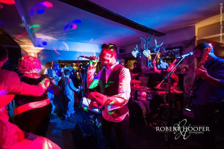 Live band and wedding guest dancing at evening wedding reception at The Stag on the River in Eashing, Surrey