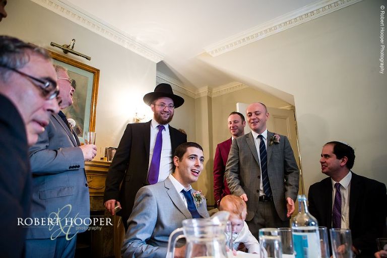 The Rabbi and male guests gather around the groom for the tish at Jewish wedding ceremony at Northbrook Park in Surrey