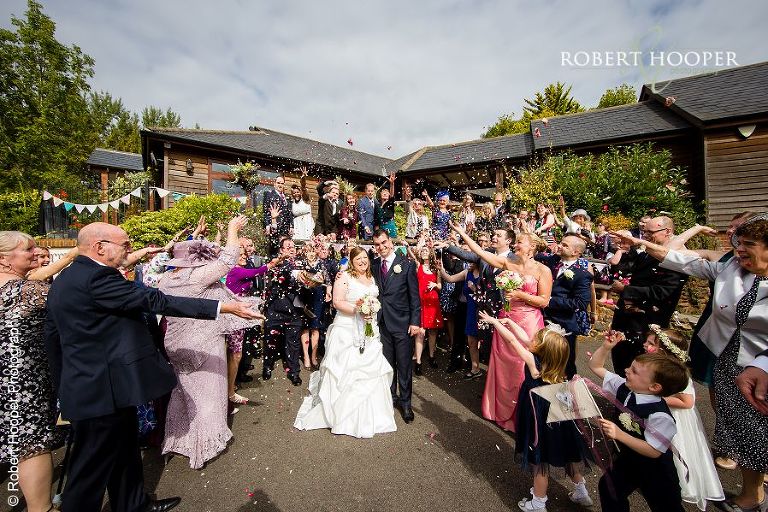 Wedding guests throw confetti after marriage ceremony at Coltsford Mill, Oxted in Surrey