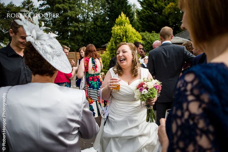 Bride enjoying her drinks reception at Coltsford Mill, Oxted in Surrey