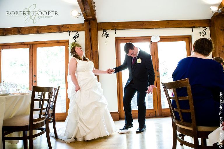 Groom breaking glass after Jewish blessing at wedding breakfast at Coltsford Mill, Oxted in Surrey