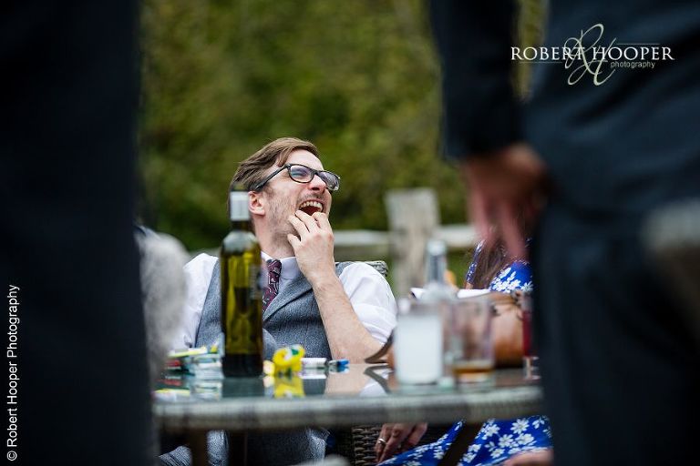 Guests laughing hilariously at wedding reception at Coltsford Mill, Oxted in Surrey
