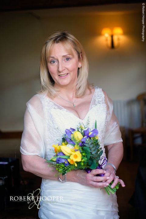 Bridal holding bouquet of spring flowers at the cottages at Oaks Farm Barn on her wedding day