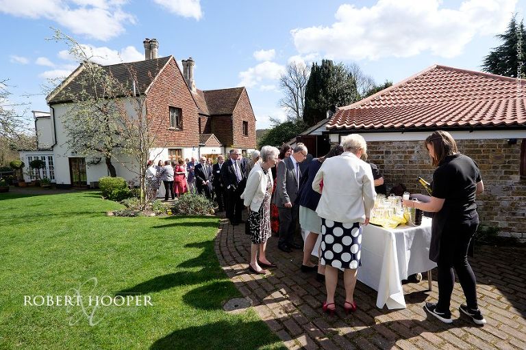 Wedding guests at drinks reception after spring wedding at Oaks Farm Barn in Surrey