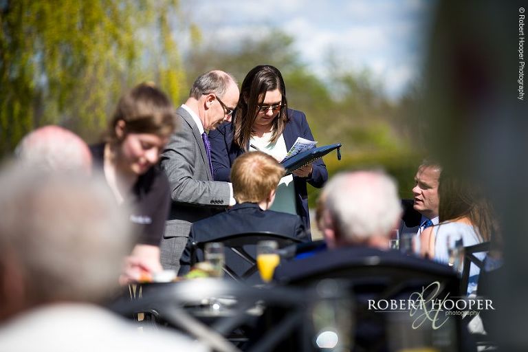 Guests participating in grand national sweepstakes on wedding day at Oaks Farm Barn, Surrey
