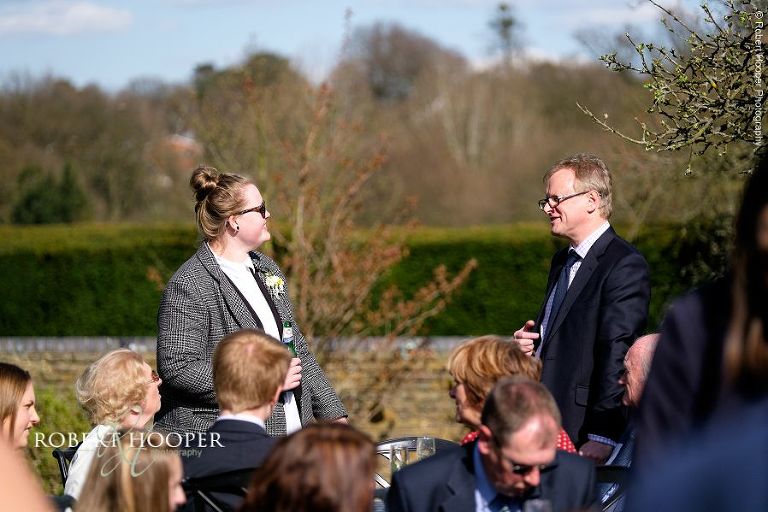 Wedding guests enjoying the spring sunshine and friends' company at Oaks Farm Barn in Surrey