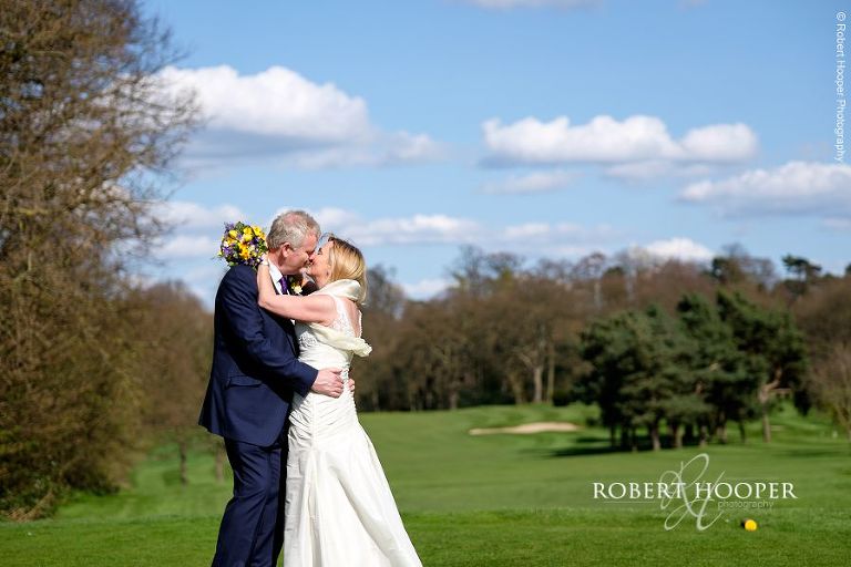 Bride and groom share a kiss on their wedding day at Oaks Farm Barn in Surrey