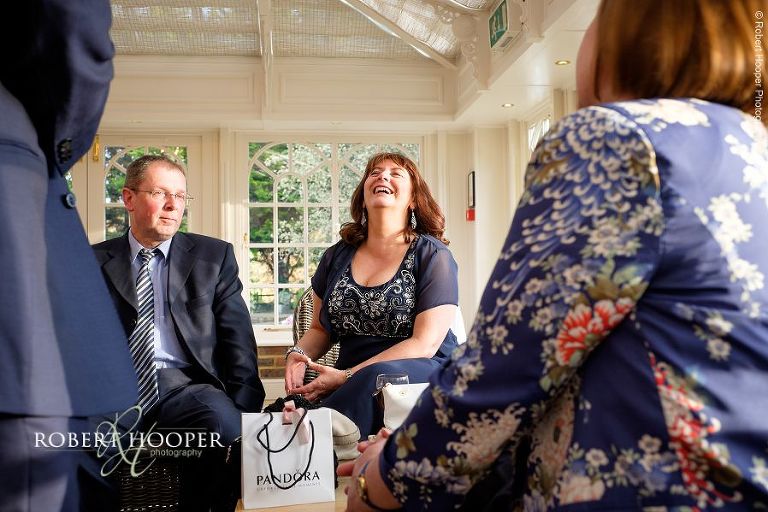 Wedding guests enjoying after-dinner drinks at Oaks Farm Barn in Surrey