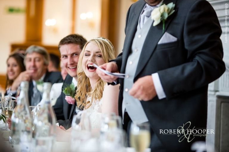 Bride laughing at dad's speech at her wedding breakfast at the London Golf Club, Kent