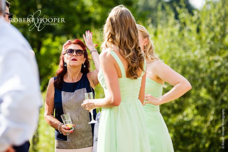 Wedding guest gesticulating to a bridesmaid at Persian wedding at Botleys Mansion in Chertsey, Surrey