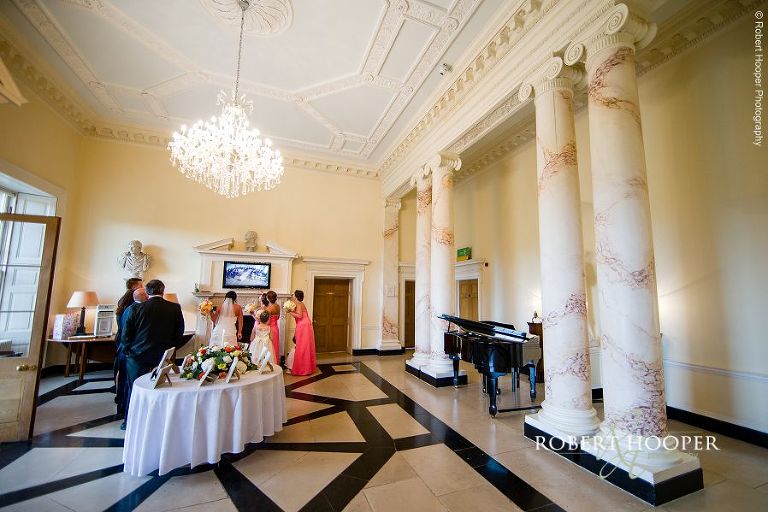 Bride and bridesmaids watching the ceremony on CCTV whilst waiting to make her entrance at Botleys Mansion, Chertsey in Surrey