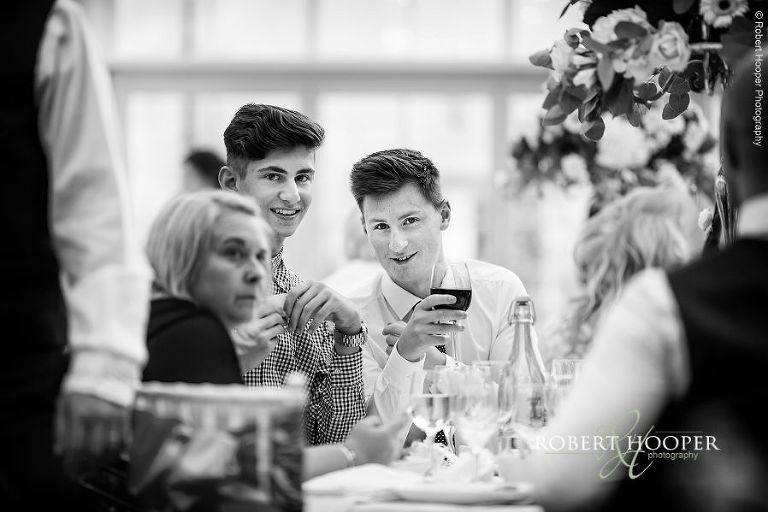 Young guests at wedding breakfast held in the glass atrium at Botleys Mansion in Surrey