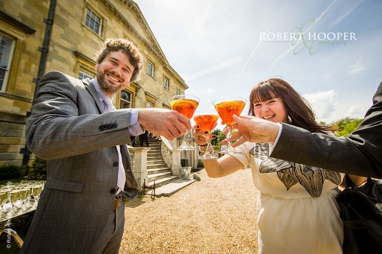 Wedding guests toasting with cocktails at reception in grounds of Botleys Mansion Surrey
