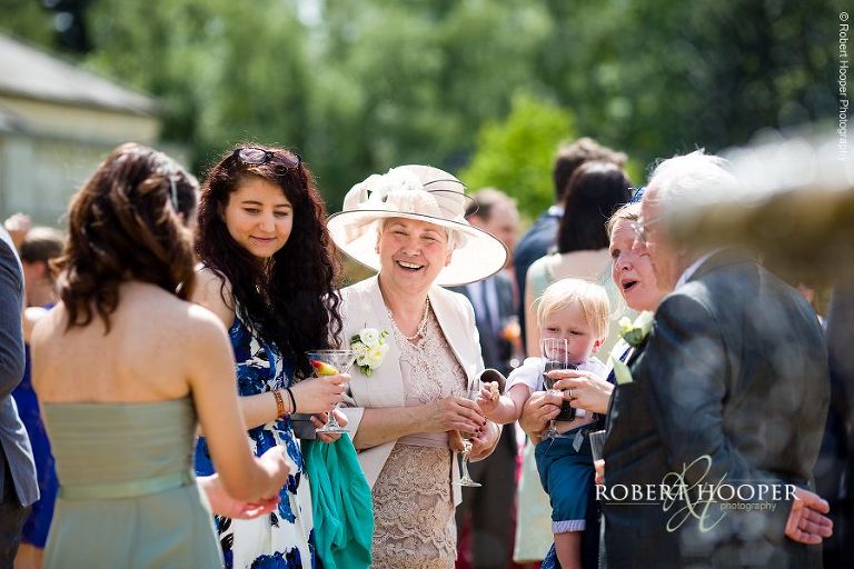 Bridesmaid and guests chatting and drinking after wedding ceremony at Botleys Mansion Surrey